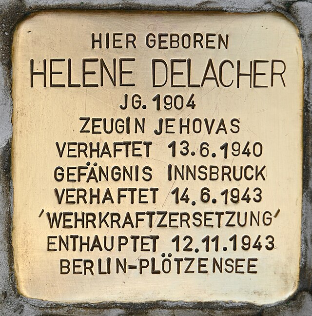 Concrete cube bearing a brass plate inscribed with the name and life dates of Helene Delacher